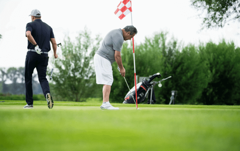 Zwei Männer auf einem Golf-Green.